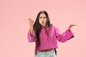 Image showing Beautiful female half-length portrait isolated on pink studio backgroud. The young emotional surprised woman