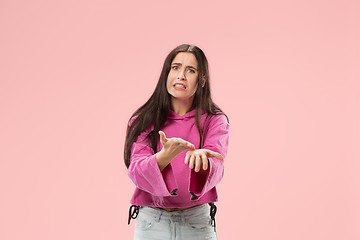 Image showing Beautiful female half-length portrait isolated on pink studio backgroud. The young emotional surprised woman