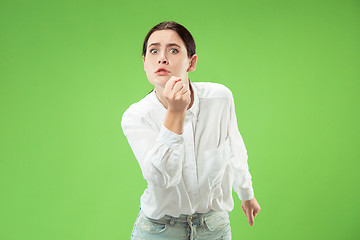 Image showing Portrait of an angry woman looking at camera isolated on a green background