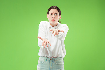 Image showing Portrait of an angry woman looking at camera isolated on a green background