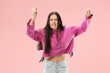 Image showing Beautiful female half-length portrait isolated on pink studio backgroud. The young emotional surprised woman