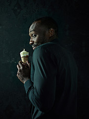 Image showing Portrait of afro american man holding ice cream