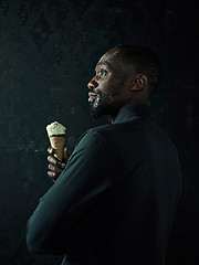 Image showing Portrait of afro american man holding ice cream