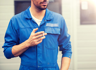 Image showing close up of auto mechanic smoking cigarette