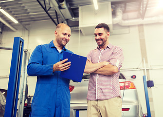 Image showing auto mechanic with clipboard and man at car shop