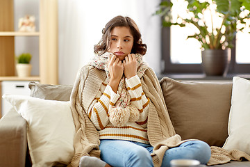 Image showing sad sick woman in blanket and scarf at home