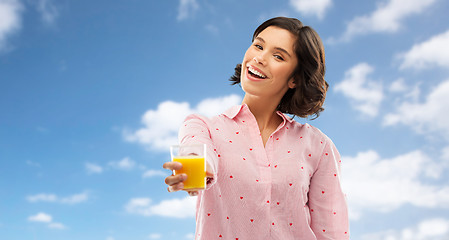 Image showing happy young woman in pajama holding orange juice