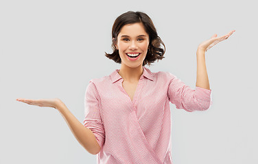 Image showing young woman in striped shirt holding something