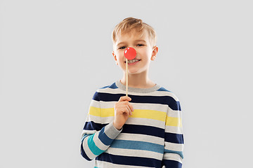 Image showing smiling boy with red clown nose party prop