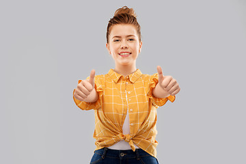 Image showing smiling red haired teenage girl showing thumbs up