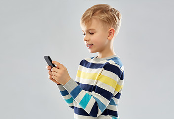 Image showing little boy in striped pullover using smartphone