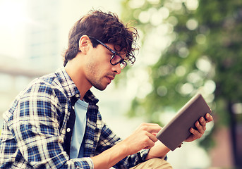 Image showing man with tablet pc sitting on city street bench