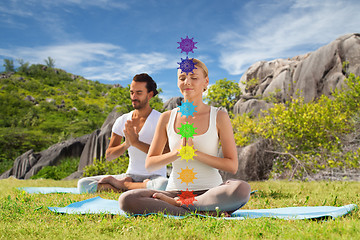 Image showing couple doing yoga in lotus pose with seven chakras