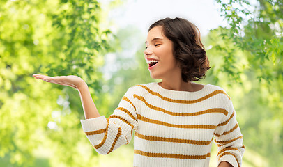 Image showing woman with empty hand over natural background