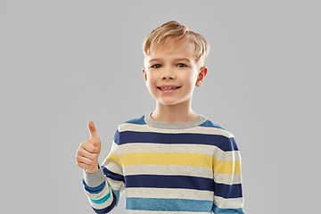 Image showing smiling boy in striped pullover showing thumbs up