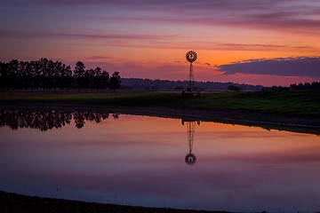 Image showing Sunrise over dam with wind mill in rural Australia