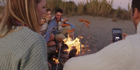 Image showing Group Of Young Friends Sitting By The Fire at beach