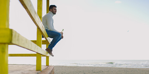 Image showing man drinking beer at the beach