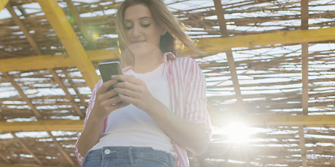 Image showing Smartphone Woman Texting On Cell Phone At Beach