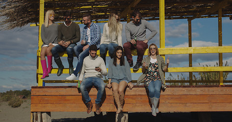 Image showing Group of friends having fun on autumn day at beach