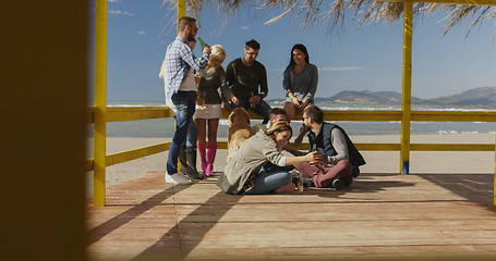 Image showing Group of friends having fun on autumn day at beach