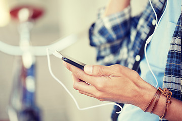 Image showing man with earphones and smartphone listening music