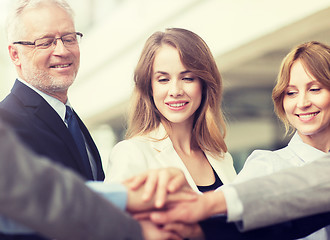 Image showing business people putting hands on top in office