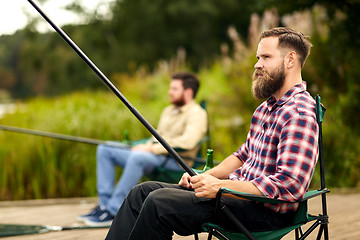 Image showing bearded man with friend fishing at lake