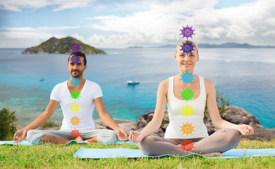 Image showing couple doing yoga in lotus pose with seven chakras