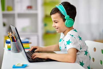 Image showing boy in headphones playing video game on laptop