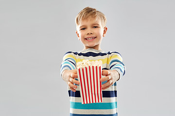 Image showing little boy holding paper bucket with popcorn