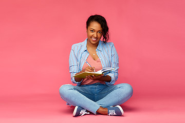 Image showing african student woman writing to diary or notebook