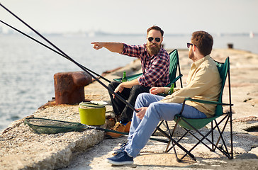 Image showing happy friends with fishing rods on pier