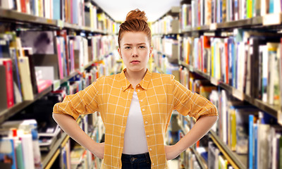 Image showing displeased red haired student girl at library