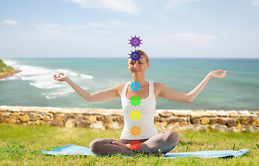 Image showing woman doing yoga in lotus pose with seven chakras