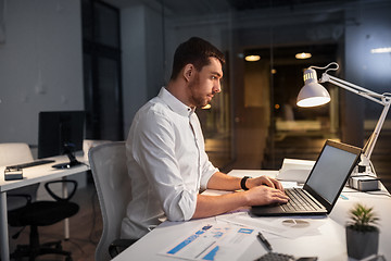 Image showing businessman with laptop working at night office