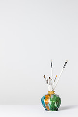 Image showing Paintbrushes in a colorful ceramic vase