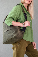 Image showing Woman in green clothes holding backpack