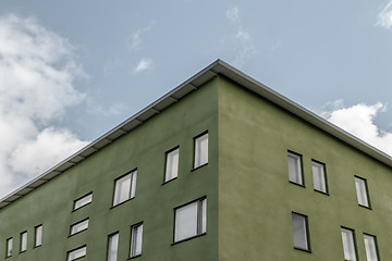 Image showing Corner of green building against blue sky