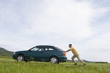 Image showing Man pushing his car