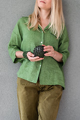 Image showing Woman in green clothes holding artichoke