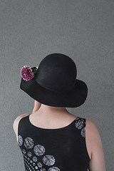 Image showing Lady with black hat and dahlia