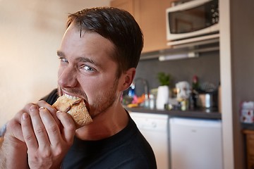 Image showing Man biting a sandwich