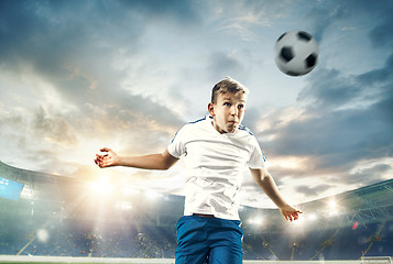 Image showing Young boy with soccer ball doing flying kick at stadium