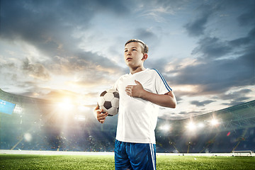 Image showing Young boy with soccer ball doing flying kick at stadium