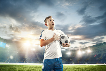 Image showing Young boy with soccer ball doing flying kick at stadium