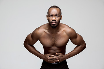 Image showing Young man overwhelmed with a pain in the stomach .