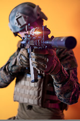 Image showing soldier in action aiming laseer sight optics yellow background