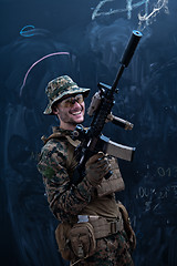 Image showing soldier firing into the air in front of black chalkboard