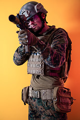 Image showing soldier in action aiming laseer sight optics yellow background